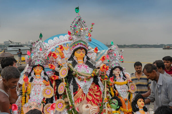 KOLKATA, WEST BENGAL, INDIA - 30 СЕНТЯБРЯ 2017: Идол богини Дурги переносится в священные речные ганги для погружения, называемые "бисоржон". Последний день фестиваля Дурга Пуджа в Бенгалии.