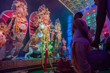 Howrah, Batı Bengal, Hindistan - 5 Ekim 2019: Kansor ghonta dindar kişi tarafından canlandırılırken Hindu Bengalli rahip Durga, Durga aarti 'ye gece çekimleri sırasında dumanın altında tapıyor..
