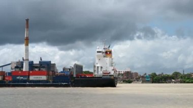 Kolkata, Batı Bengal, Hindistan - 29 Temmuz 2019: Ganj Nehri 'nden geçen malları taşıyan büyük bir mavna. Büyük baca ve bulutlu gökyüzü arka planına sahip modern endüstriyel fabrika. Büyük kopyalama alanı.