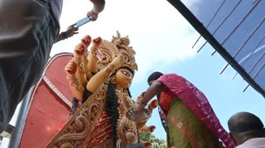 Howrah, Batı Bengal, Hindistan - 8 Ekim 2019: Vijayadashami, tanrıça Durga 'nın alnına sindur, vermilion sürerek şeker sunan Hindu bir kadınla evlendi. Durga puja festivali ritüeli.