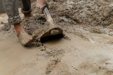 Yerli işçilerin çimento ve suyu elle karıştırması için bir kürek kullanmışlar. Resim yükle.