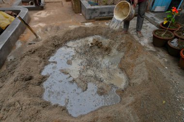 Yerli işçilerin çimento ve suyu elle karıştırması için bir kürek kullanmışlar. Resim yükle.