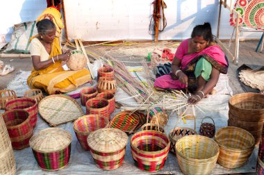 KOLKATA, Batı BENGAL, INDIA - 14 Aralık 2013: Kimliği belirsiz kadın hasır sepetler yapıyor, Kolkata 'daki El Sanatları Fuarı' nda sergileniyor - Asya 'nın en büyük el sanatları fuarı.