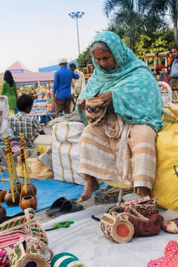 KOLKATA, Batı BENGAL, INDIA - NOVEMBER 23RD 2014: Asya 'nın en büyük el sanatları fuarı olan Kolkata' daki el sanatları fuarı sırasında el yapımı jüt çantaları yapan tanımlanamayan Hintli kadın.