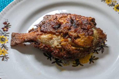 Kızarmış pomfret balığı beyaz bir tabakta servis edilir, baharatlı Hint yemeği. Pomfretler Bramidae familyasına ait balık türleridir..