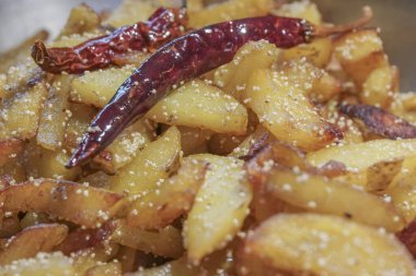 Kızarmış patates parçalarıyla kırmızı biberli bir fast food tabağı yakın plan. Hintliler arasında lezzetli bir aperatif olarak popülerdir..