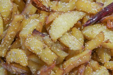 Kızarmış patates parçalarıyla kırmızı biberli bir fast food tabağı yakın plan. Hintliler arasında lezzetli bir aperatif olarak popülerdir..