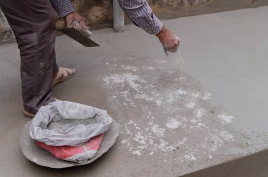 Hindistan işçiliği, düz mala kullanarak zemini düzleştiriyor ve elle beton dağıtıyor. Stok görüntüsü..
