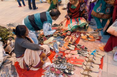 KOLKATA, Batı BENGAL, INDIA - 12 HAZİRAN 2014: Asya 'nın en büyük el sanatları fuarı olan Kolkata' da el sanatları fuarında ayakkabı satan tanımlanamayan kişiler.