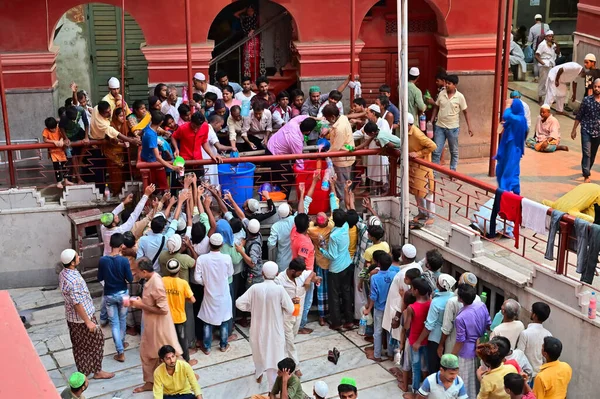 KOLKATA, Batı BENGAL, INDIA - 27 Mayıs 2019: Roja veya Ramazan ayında Nakhoda Mashid 'de iftar partisi adı verilen içecekleri için sıraya giren Müslüman insanlar.