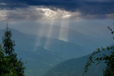 Rabangla, Sikkim, Hindistan 'dan gelen güneş ışınları. Ön planda Slihoutte ağaçları ve arka planda Himalaya dağları. Sikkim 'li Büyük Himalayalar' ın muhteşem manzarası..