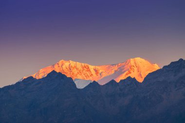 Dünya 'nın üçüncü en yüksek dağı olan Kangchenjunga, Himalaya' nın Sikkim, Hindistan 'dan güneye uzanan Kabru Dağı' nda güneşin doğuşunun güzel ilk ışığı. Nepal Hindistan sınırı.