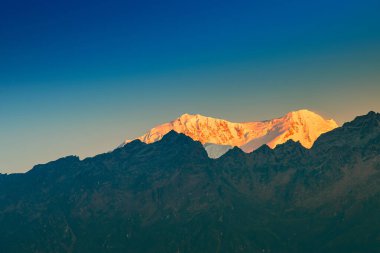 Dünya 'nın üçüncü en yüksek dağı olan Kangchenjunga, Himalaya' nın Sikkim, Hindistan 'dan güneye uzanan Kabru Dağı' nda güneşin doğuşunun güzel ilk ışığı. Nepal Hindistan sınırı.