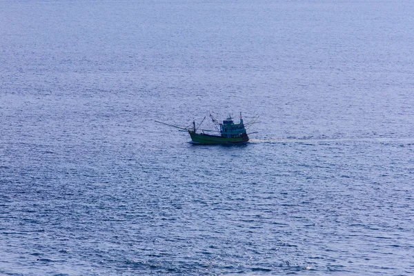 Colorful marine landscape with fisherman boat against deep blue sea under blue sky in the ocean on the cloudy day at Phuket, Thailand.