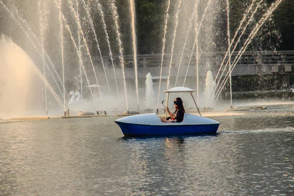 バンコク ルンピニ公園で湖の美しい噴水 静かな公園の池 休日や仕事有閑の後の人々 のための都市の真ん中に船と庭 — ストック写真