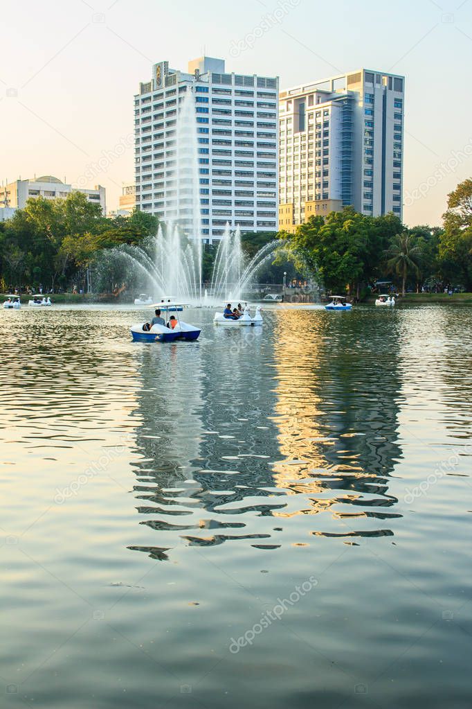 Beautiful fountains in the lake at Lumpini Park, Bangkok Thailand. Tranquil public park garden with pond, fountain, and boats in the middle of the city for people on holiday or after work leisured.