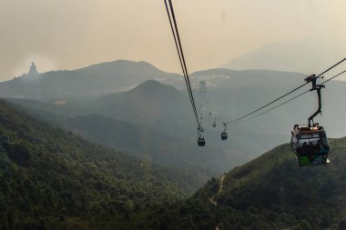 Tele yakınlaştırma görünümü Ngong Ping 360 kablo araba Po Lin manastırda Lantau Island, Hong Kong, dağ tepe üzerinde dev Tian Tan Buddha heykeli göster