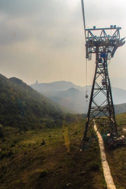 Tele yakınlaştırma görünümü Ngong Ping 360 kablo araba Po Lin manastırda Lantau Island, Hong Kong, dağ tepe üzerinde dev Tian Tan Buddha heykeli göster