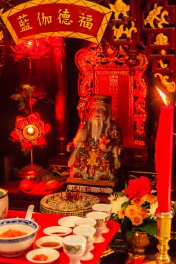 Kırmızı mum ve renkli heykeli Cai Shen, Çin zenginlik tanrısı, Tanrı'nın iyi şanslar getirmek için bir sembol servet. Cai Shen, Çin Tanrı refah, popüler bir Çin yeni yılı sembolü