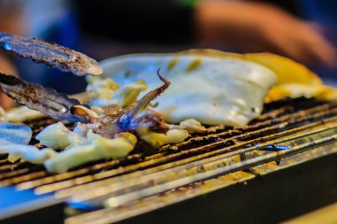 Mürekkep balığı, gece pazarı Tayland egzotik Street Foods'da bir closeup ızgara. Restoran deniz ürünleri büfesi için ateşe Izgara kalamar.