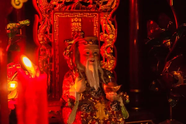 红色蜡烛和五颜六色的彩雕雕像 中国财富之神 财富之神 这是带来好运的象征 中国繁荣之神蔡沈 一个受欢迎的中国新年符号 — 图库照片