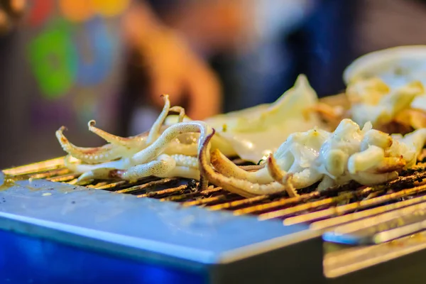 クローズ アップの焼きイカ 夜市でタイのエキゾチックなストリート食品 レストランでシーフードのために火に焼きイカ — ストック写真