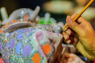 Taylandlı kadın sanatçı el kadar Benjarong desenleri, ünlü Tay 5 renkli porselen seramik mallar şaheser boyama sırasında kapatın.