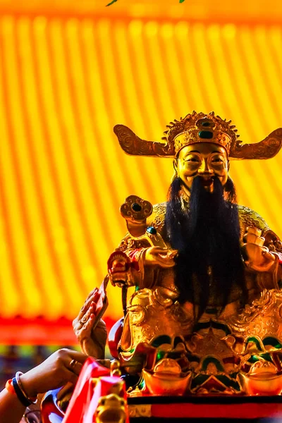 人们拿钞票与中国的财富之神 财富之神的形象联系在一起 他们相信这将使他们富有 中国春节在中国寺庙 — 图库照片