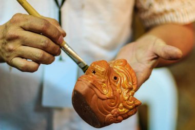 Tay heykeltıraş eller yukarıda hanuman kukla oyuncak Gece Pazarı'na adlı şaheseri boyama sırasında kapatın