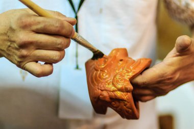 Tay heykeltıraş eller yukarıda hanuman kukla oyuncak Gece Pazarı'na adlı şaheseri boyama sırasında kapatın