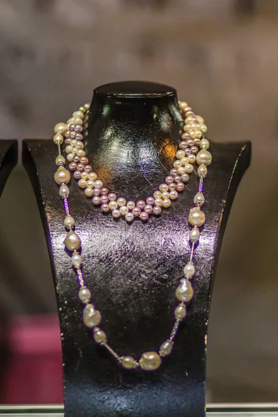 美丽的长珍珠项链在一家珠宝店展出 光线差 有噪音颗粒拍摄 — 图库照片