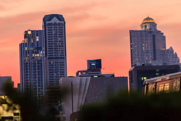 夕方仕事の後は オフィスの人々 は日没後帰宅する Bts スカイトレインをキャッチします 建物夕暮れ夜に夜にバンコクで背の高い超高層ビル 首都の概念での生活 — ストック写真