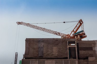 Bina inşaat kule vinç ile dramatik gökyüzü arka plan altında üstte gökdelen.