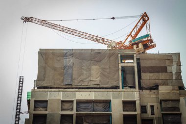 Bina inşaat kule vinç ile dramatik gökyüzü arka plan altında üstte gökdelen.