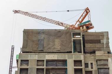 Bina inşaat kule vinç ile dramatik gökyüzü arka plan altında üstte gökdelen.