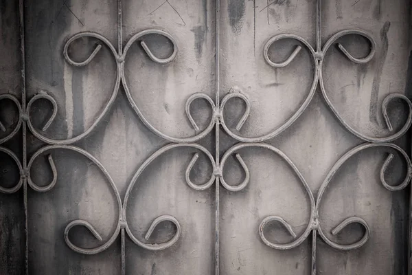 Eski dövme demir çubukları grunge ve paslı çelik arka kapısı. Demir ızgara süs güzelleşmek ayrıntılı arka plan. Eski paslı çit metalik kapısı desenli kavisli çelik arka plan.