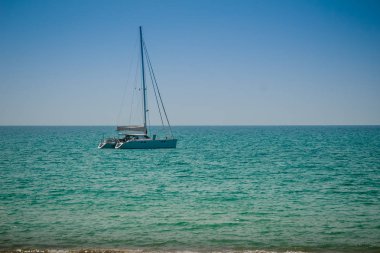 Salma tekne palamarla sahil tarafında, orman plaj görünümden. Orman ağaç ve Yelkenli deniz manzarası görünümü. Yat ve ağaç ile huzurlu plaj. Yelkenli veya salma tekne Naiyang Beach Phuket ağaç çerçevesindeki
