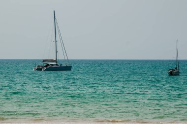 Salma tekne palamarla sahil tarafında, orman plaj görünümden. Orman ağaç ve Yelkenli deniz manzarası görünümü. Yat ve ağaç ile huzurlu plaj. Yelkenli veya salma tekne Naiyang Beach Phuket ağaç çerçevesindeki