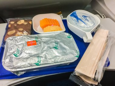 Bangkok, Tayland - 21 Şubat 2017: pirinç, tavuk, tatlı pasta ve papaya ile ekonomi sınıfı uçak masanın üzerine kurulu hizmet gıda.