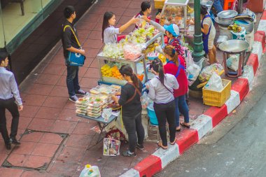 Bangkok, Tayland - 21 Şubat 2017: Sokak gıda işportacı gıda Silom Road Bangkok, Tayland için yakın patika üzerinde müşterilerine satıyor.