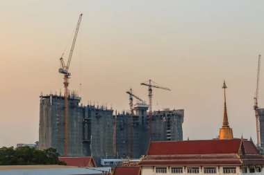 Bomu kule vinç yüksek doğmak bina arasında çelik çerçeve üzerinde kat mülkiyeti inşaat sahasında. Bina inşaat kule vinç ile dramatik gökyüzü arka plan altında üstte gökdelen.