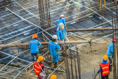 İnşaat işçileri beton sonrası gerginlik döşeme çalışmalarında yağıyor. Mason işçiler iş inşaat sahasında betonlama sırasında hortum beton pompası ya da diğer adıyla fil hortumu taşıyan