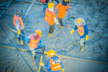 Betonlama işçi döktü sıvı güçlü zemin plakaları oluşturmak için bir çelik takviye beton tesviye.