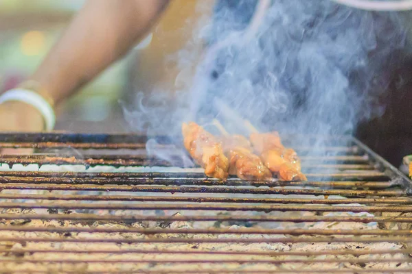バンコク タイの屋台の食べ物店の煙 ステーキ ロースト ポーク焼きの豚肉のサテを焼くベンダーを閉じる — ストック写真