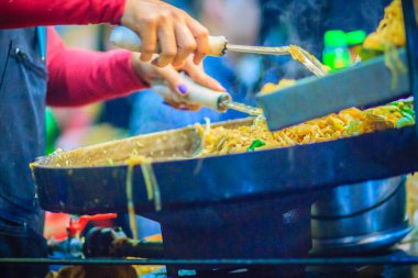 Padthai, orijinal Tayland kızarmış şehriye, karides ve yaygın bir sokak gıda olarak Tayland'da popüler servis yumurta ile tavada kızartılmış erişte için pişirme sırasında satıcı el kadar kapatın