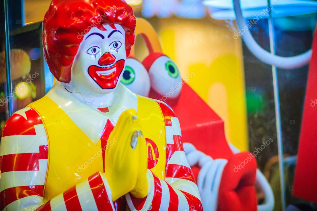 Bangkok, Thailand - March 2, 2017:  Mc Donald's doll in Thai culture greeting customer in front of the shop. McDonalds shop at the entrance with brand's logo and welcome doll.