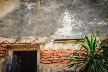 Eski kapı ve grungy tuğla duvar ile eski bir Budist kilise Gable sonu.