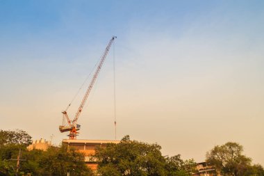 Bomu kule vinç yüksek doğmak bina arasında çelik çerçeve üzerinde kat mülkiyeti inşaat sahasında. Bina inşaat kule vinç ile dramatik gökyüzü arka plan altında üstte gökdelen.