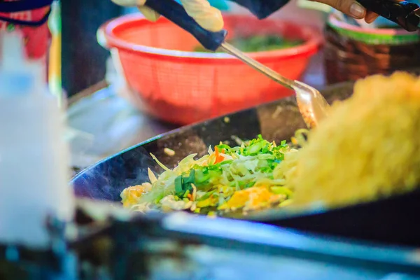 Padthai, orijinal Tayland kızarmış şehriye, karides ve yaygın bir sokak gıda olarak Tayland'da popüler servis yumurta ile tavada kızartılmış erişte için pişirme sırasında satıcı el kadar kapatın