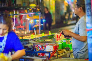 Bangkok, Tayland - 2 Mart 2017: Satıcı Khao San Road gece pazarı, Bangkok, Tayland, Thailand, kalamar ızgara. Izgara kalamar bir popüler sokak Bangkok besindir.